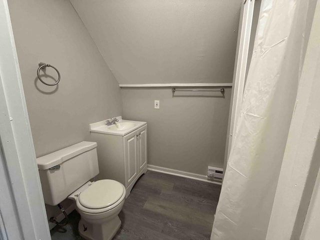 bathroom featuring wood finished floors, vanity, baseboards, toilet, and lofted ceiling