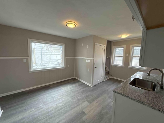dining room featuring dark wood-type flooring, stairway, and baseboards