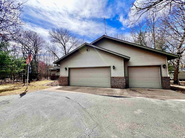 489 Sir Winston Trl, Nekoosa, WI 54457 - view of side of home featuring brick siding and asphalt driveway