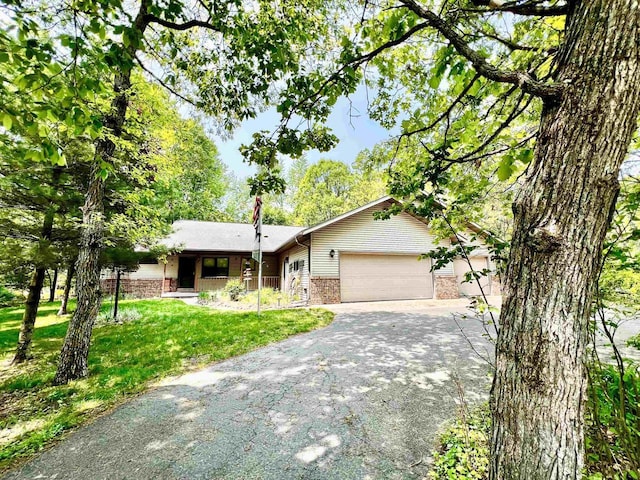 489 Sir Winston Trl, Nekoosa, WI 54457 - single story home with driveway, a garage, a front yard, and brick siding