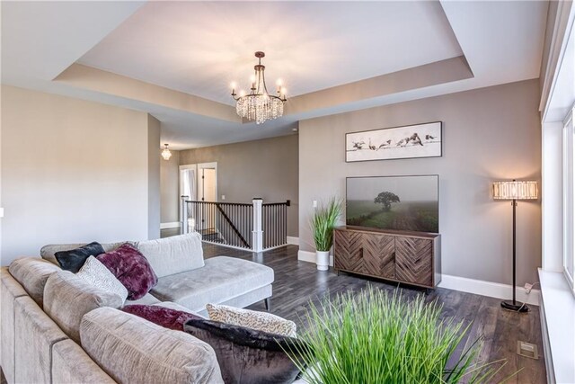 6468 Aspen Ridge Dr, Eau Claire, WI 54703 - living area with baseboards, a tray ceiling, a chandelier, and dark wood-style floors