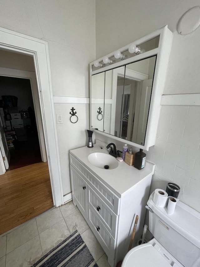 half bathroom featuring tile patterned floors and vanity