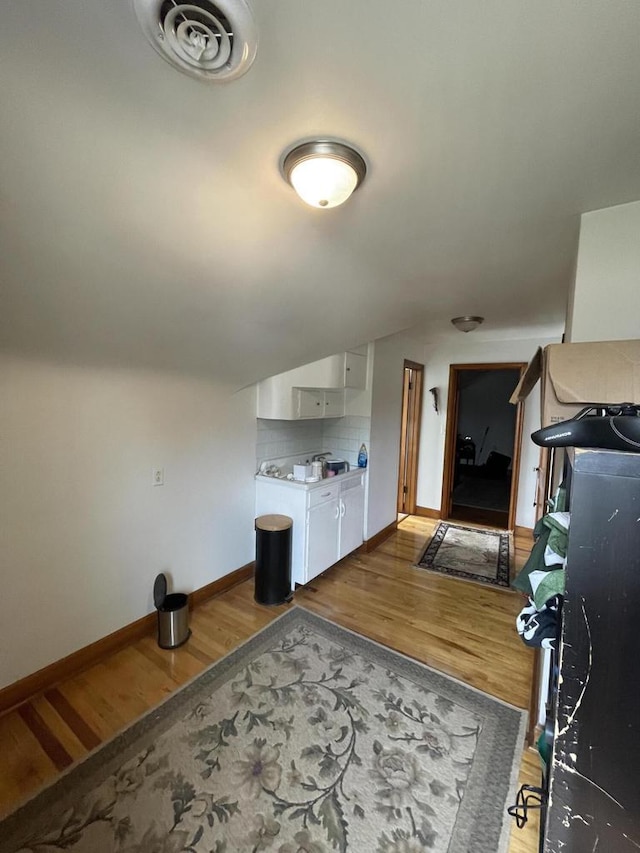 bonus room featuring vaulted ceiling, baseboards, wood finished floors, and visible vents