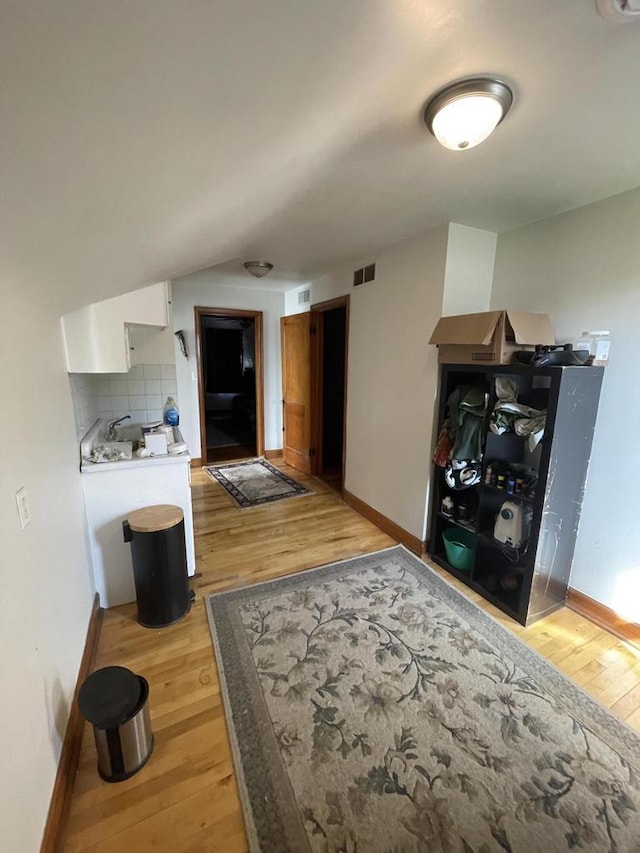 interior space with light wood finished floors, baseboards, and visible vents