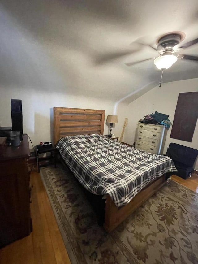 bedroom featuring lofted ceiling, a ceiling fan, and wood finished floors