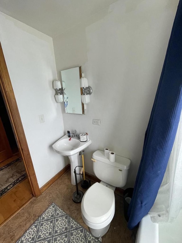 bathroom featuring toilet and baseboards