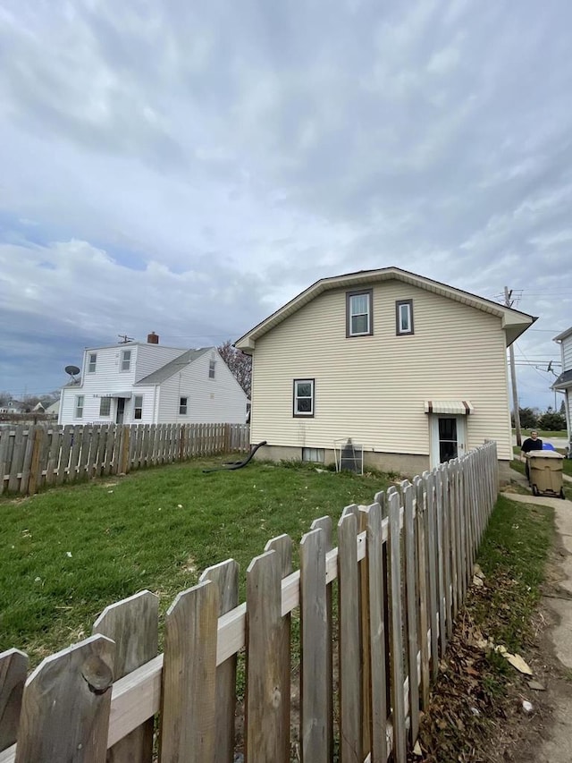 view of side of property with a yard and fence