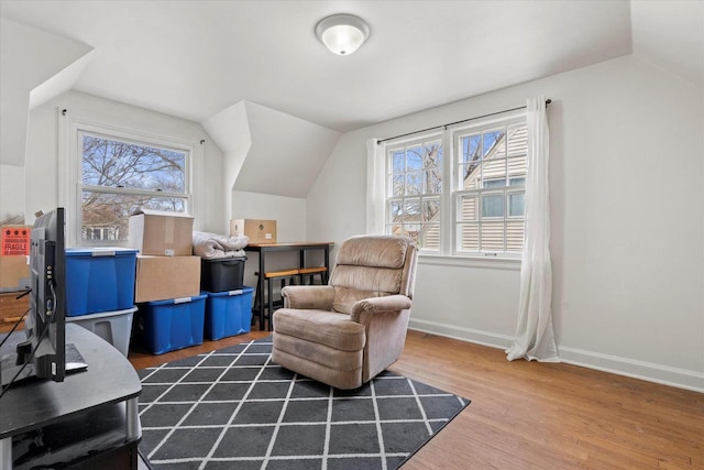 sitting room with lofted ceiling, wood finished floors, and a healthy amount of sunlight