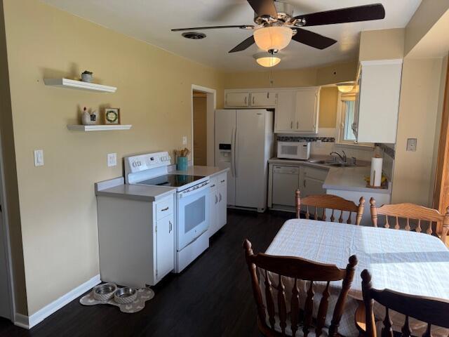 kitchen with open shelves, a sink, white appliances, a ceiling fan, and dark wood-type flooring