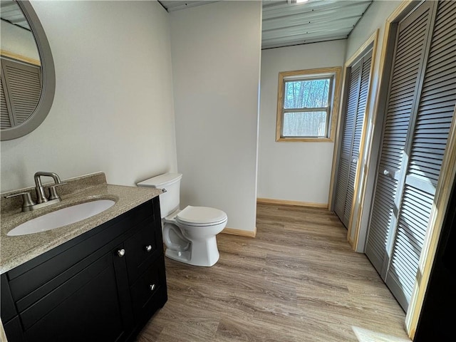 4607N Koeppler Rd, Ojibwa, WI 54862 - bathroom featuring a closet, toilet, vanity, wood finished floors, and baseboards