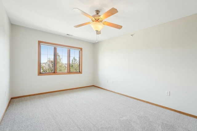 empty room featuring light colored carpet, ceiling fan, baseboards, and visible vents