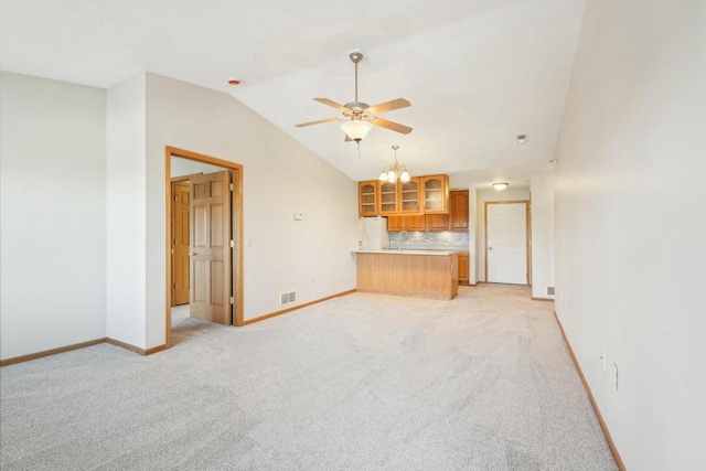 unfurnished living room with lofted ceiling, light carpet, baseboards, and ceiling fan with notable chandelier
