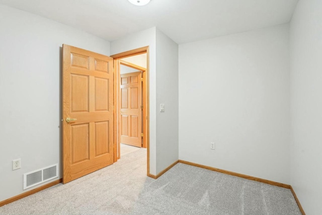 unfurnished bedroom with carpet, visible vents, and baseboards