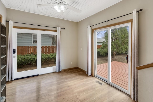 doorway featuring ceiling fan, baseboards, visible vents, and light wood-style flooring