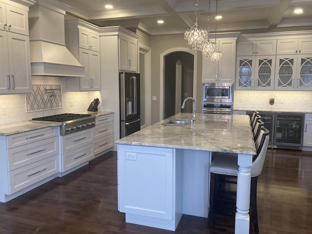 4922 Saint Annes Dr, Waunakee, WI 53597 - kitchen with appliances with stainless steel finishes, a sink, beverage cooler, custom range hood, and coffered ceiling