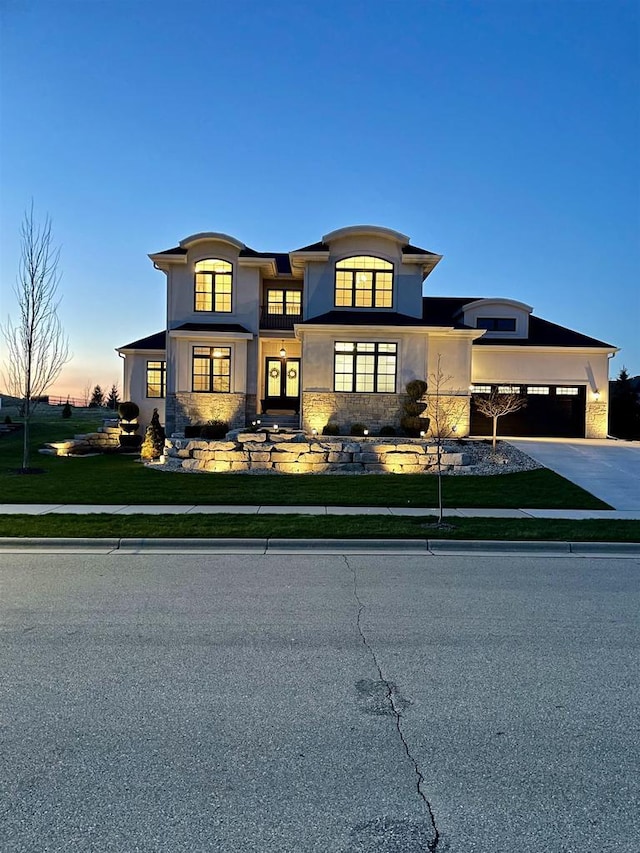 4922 Saint Annes Dr, Waunakee, WI 53597 - view of front of house featuring concrete driveway, an attached garage, a front yard, and stucco siding