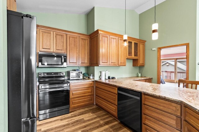 kitchen with high vaulted ceiling, light stone countertops, stainless steel appliances, and dark wood-style floors