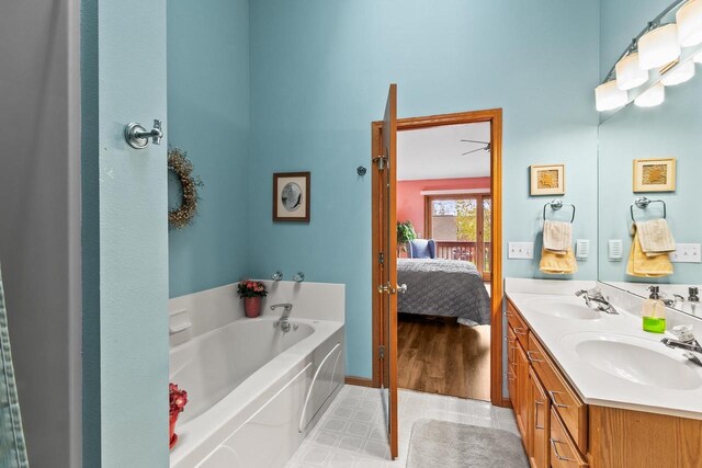 ensuite bathroom with a sink, a high ceiling, a bath, and connected bathroom