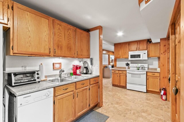 kitchen with a sink, white appliances, light countertops, recessed lighting, and a toaster