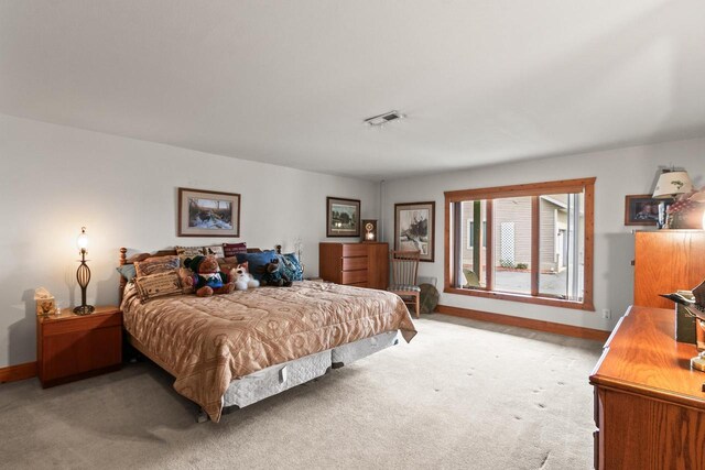 bedroom featuring baseboards, visible vents, and light carpet