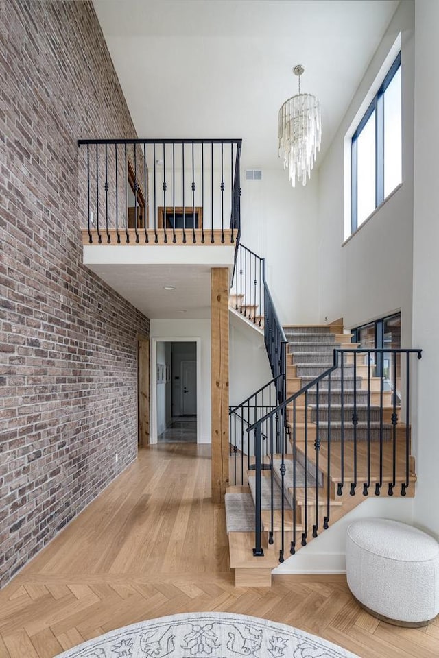 9458 Warner Rd, Winneconne, WI 54986 - stairway with a high ceiling, brick wall, and a chandelier