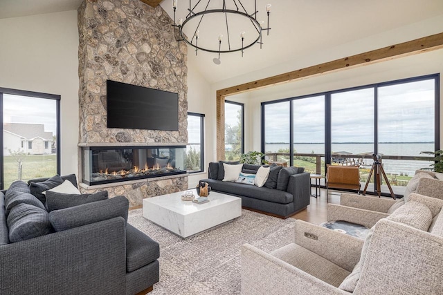 9458 Warner Rd, Winneconne, WI 54986 - living area featuring a stone fireplace, wood finished floors, a chandelier, and high vaulted ceiling