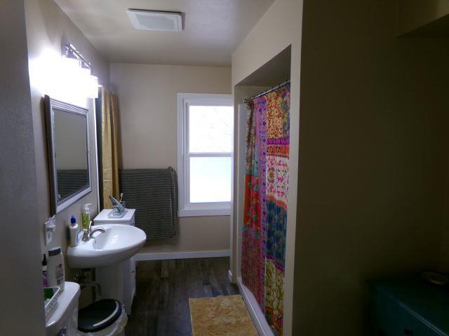 full bathroom featuring baseboards, a shower with curtain, and wood finished floors