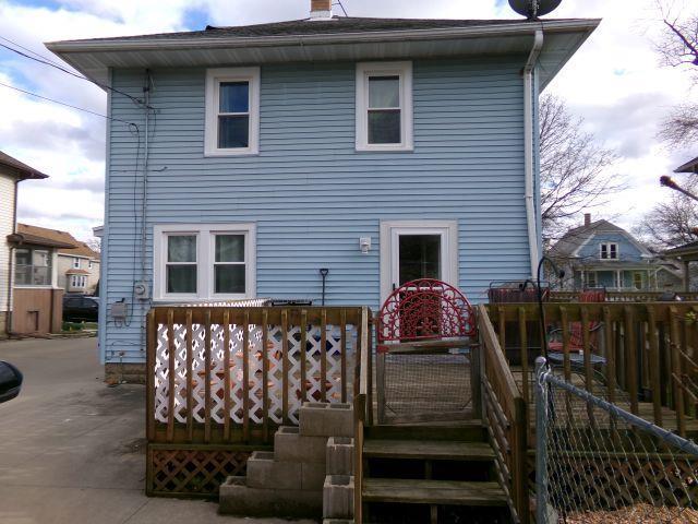 back of house with fence, a chimney, and a deck