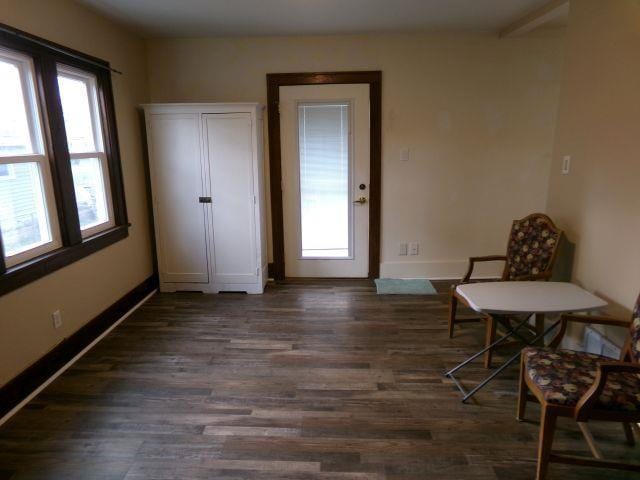 sitting room with baseboards and dark wood-style floors