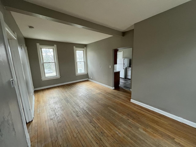 spare room with baseboards and wood-type flooring