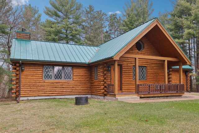 N7589 Lakeside Dr, Portage, WI 53901 - log-style house featuring a chimney, a front yard, metal roof, log exterior, and a standing seam roof