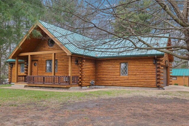 N7589 Lakeside Dr, Portage, WI 53901 - cabin featuring dirt driveway, metal roof, log siding, and covered porch