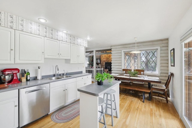 N7589 Lakeside Dr, Portage, WI 53901 - kitchen with rustic walls, white cabinets, stainless steel dishwasher, a sink, and light wood-style floors
