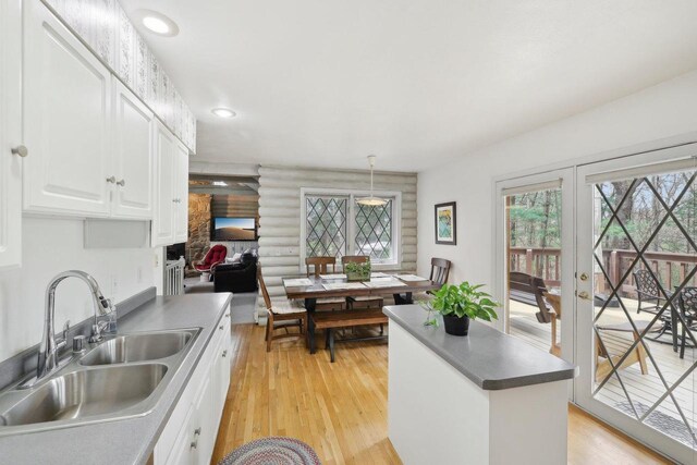 N7589 Lakeside Dr, Portage, WI 53901 - kitchen featuring light wood-type flooring, log walls, white cabinets, and a sink