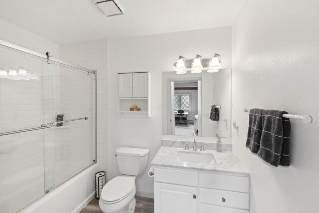 N7589 Lakeside Dr, Portage, WI 53901 - bathroom featuring toilet, vanity, and enclosed tub / shower combo