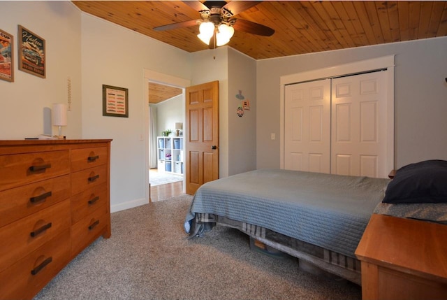 bedroom with a ceiling fan, a closet, wooden ceiling, and carpet floors