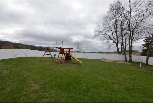 view of yard with a fenced backyard and a playground
