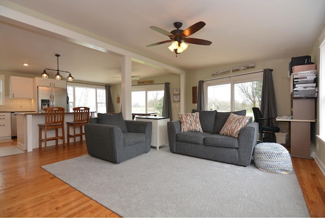 living room with light wood-type flooring and ceiling fan