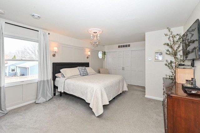 bedroom with baseboards, visible vents, a closet, and light colored carpet