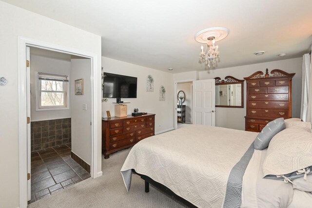 carpeted bedroom featuring baseboards and a notable chandelier