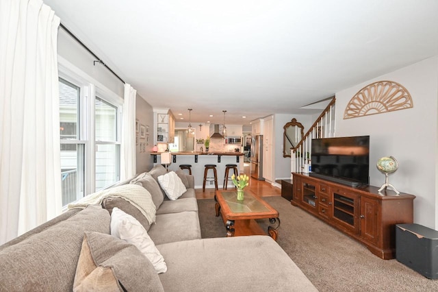 living room featuring stairway and light colored carpet