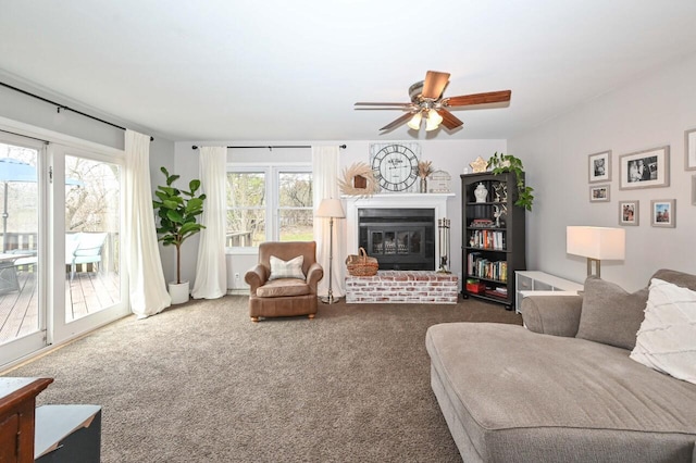 carpeted living area with a ceiling fan and a brick fireplace
