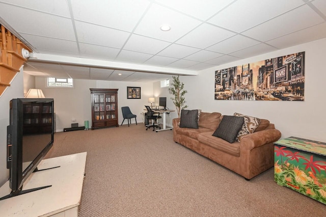 carpeted living room featuring a drop ceiling
