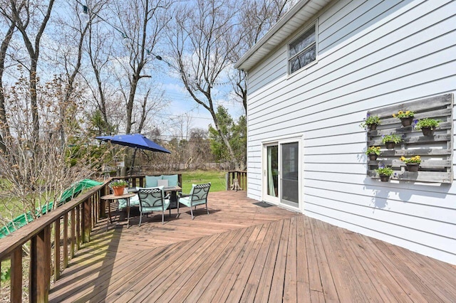 wooden terrace with an outdoor living space