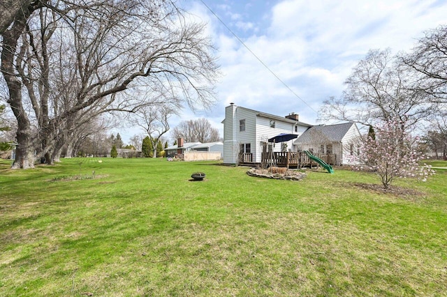 view of yard featuring an outdoor fire pit and a wooden deck