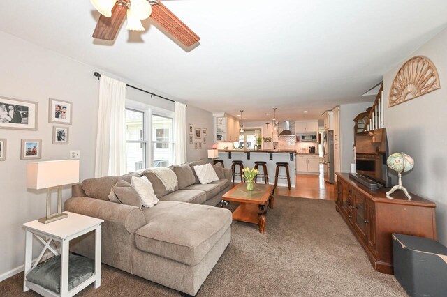living room with a ceiling fan and light carpet