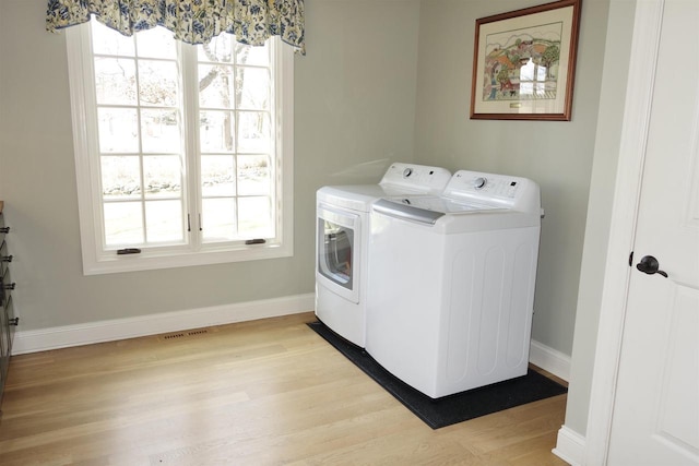 washroom with plenty of natural light, washer and dryer, laundry area, and light wood-style flooring