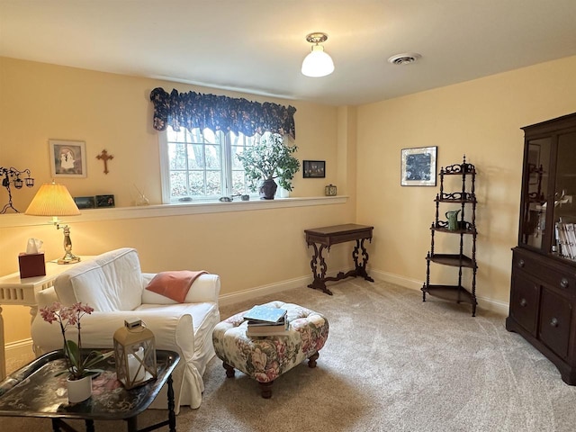 living area with light carpet, baseboards, and visible vents