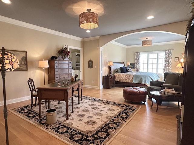 bedroom featuring arched walkways, light wood-style floors, and baseboards