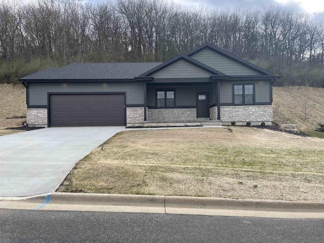 4021 Red Hawk Run, Black Earth, WI 53515 - view of front of property featuring a front lawn, concrete driveway, an attached garage, covered porch, and stone siding